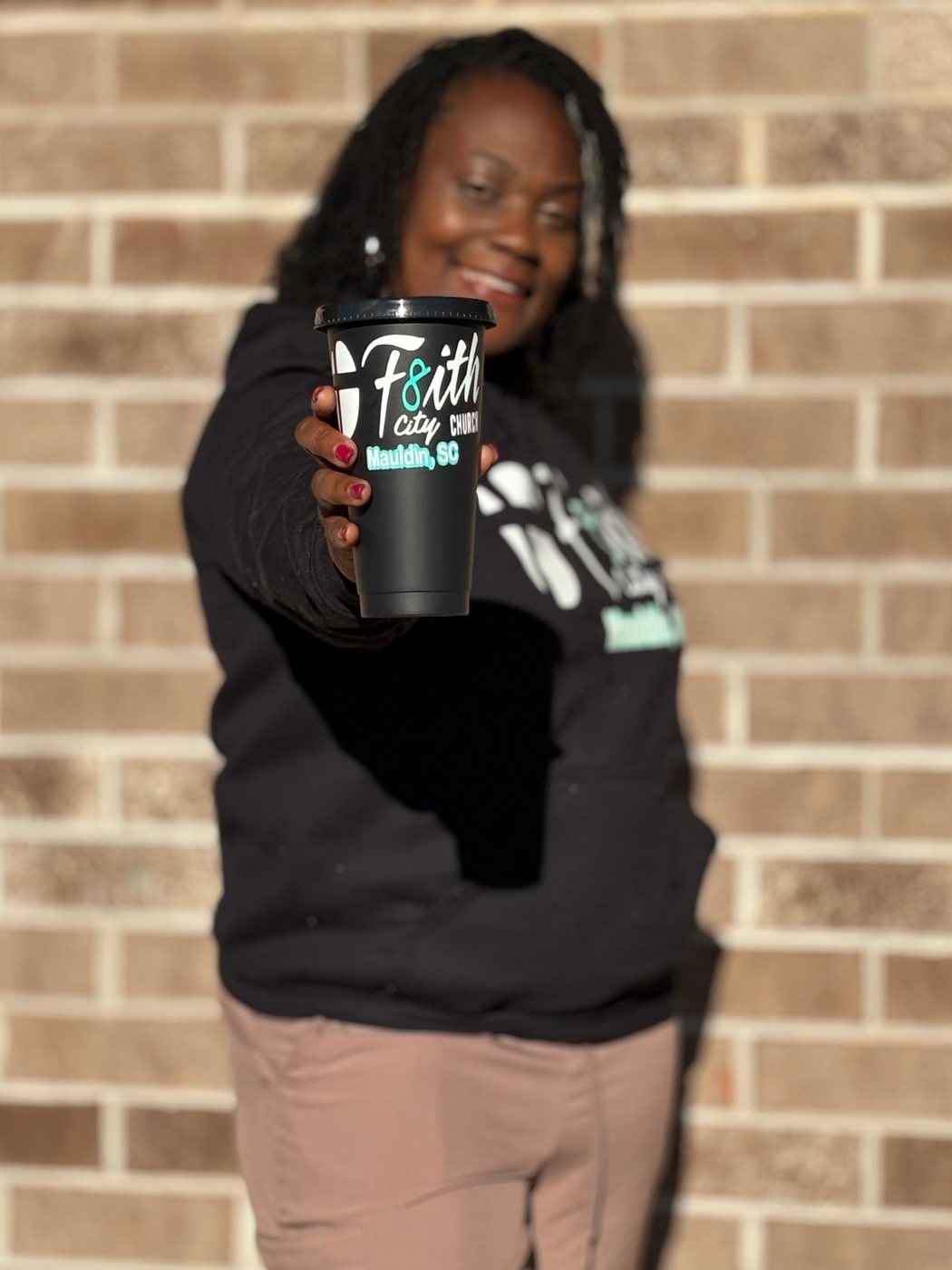 Church member holding the F8ith City tumbler