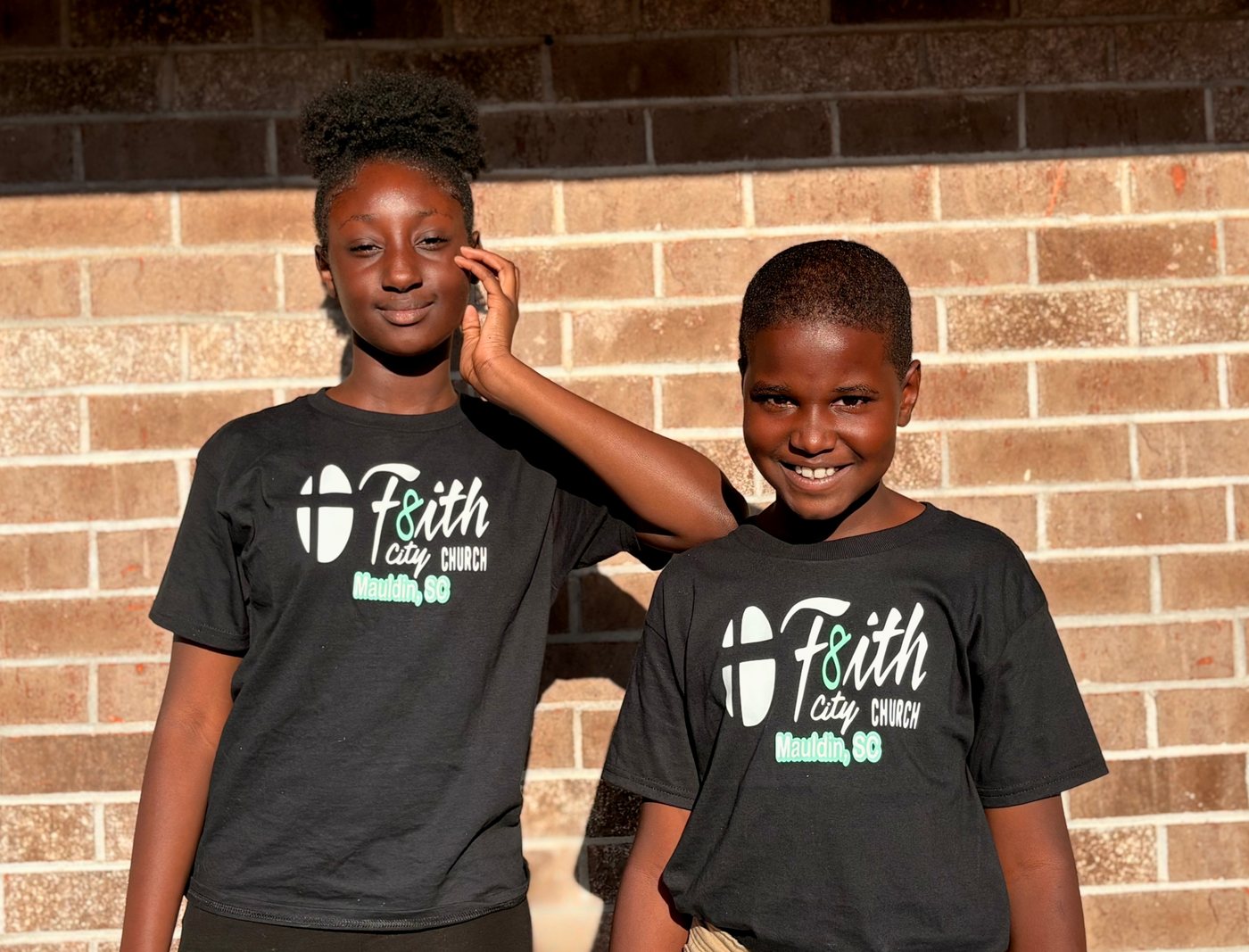 Two kids wearing the Youth T-Shirt
